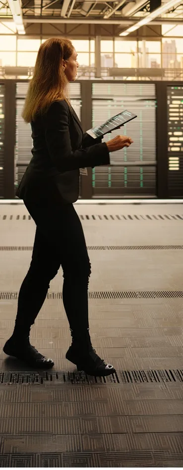 A woman in a suit is holding a tennis racket.