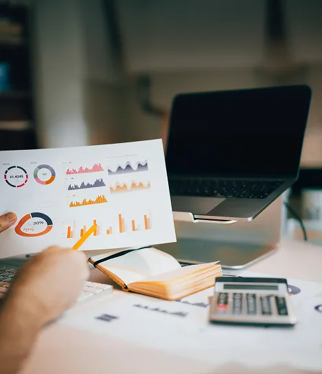 A person holding up a piece of paper with graphs on it.