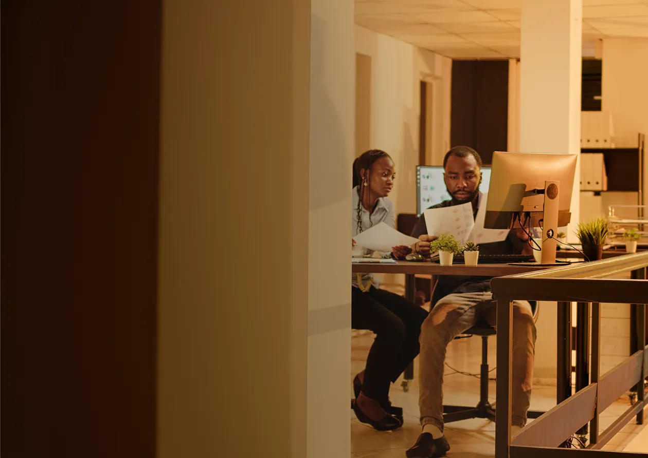 A couple of people sitting at a table with a laptop.