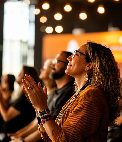 A group of people sitting in a room clapping.