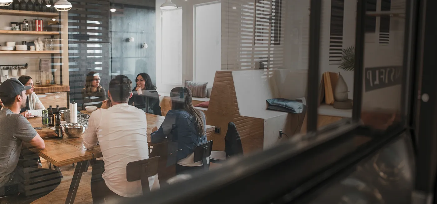 A group of people sitting around a wooden table.