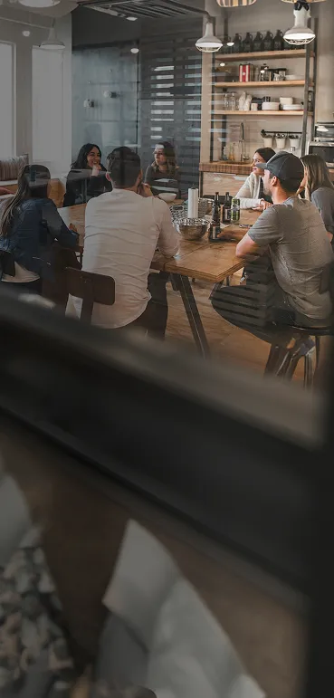 A group of people sitting around a wooden table.