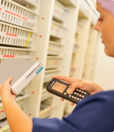 A woman in a pharmacy holding a remote control.