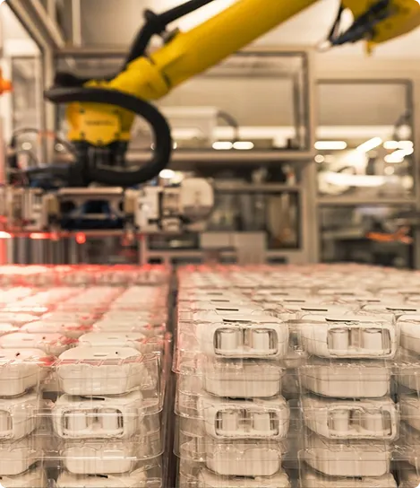 A conveyor belt filled with lots of plastic containers.