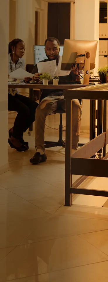 A group of people sitting at a table with laptops.