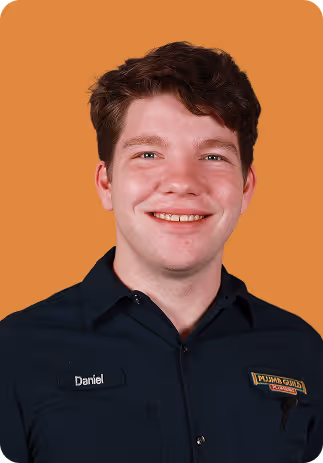 Smiling young man with short brown hair wearing a dark blue shirt.
