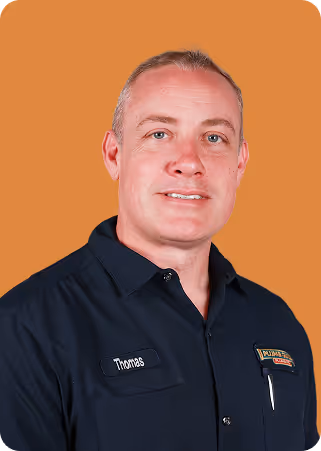 Portrait of a man wearing a black work shirt with company patches.