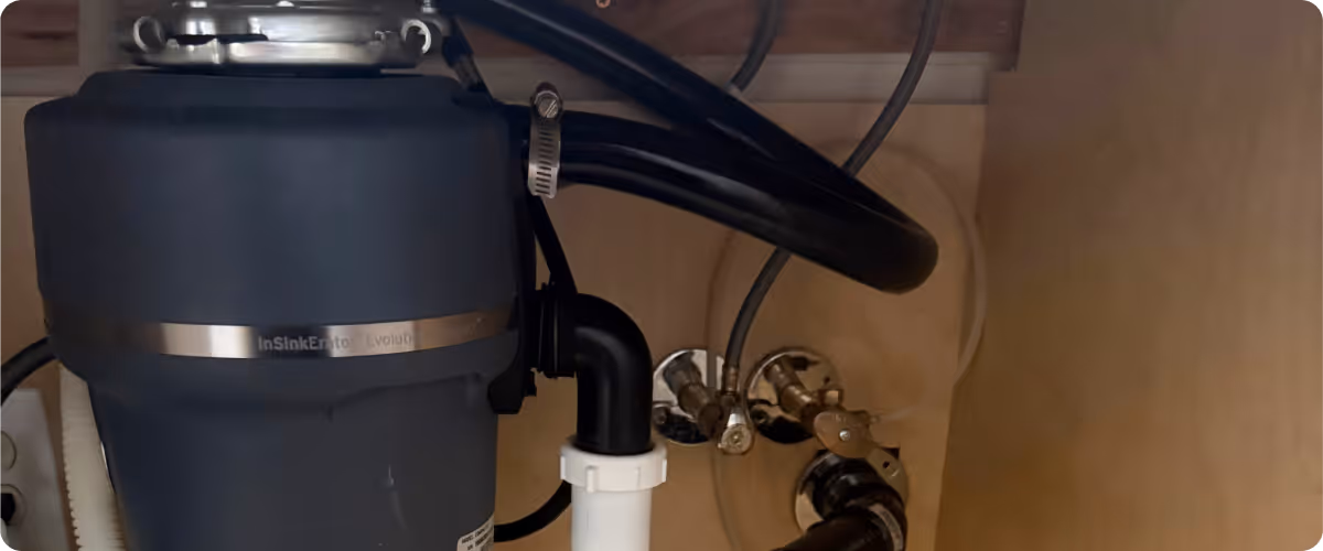InSinkErator Evolution Compact garbage disposal unit installed under kitchen sink.