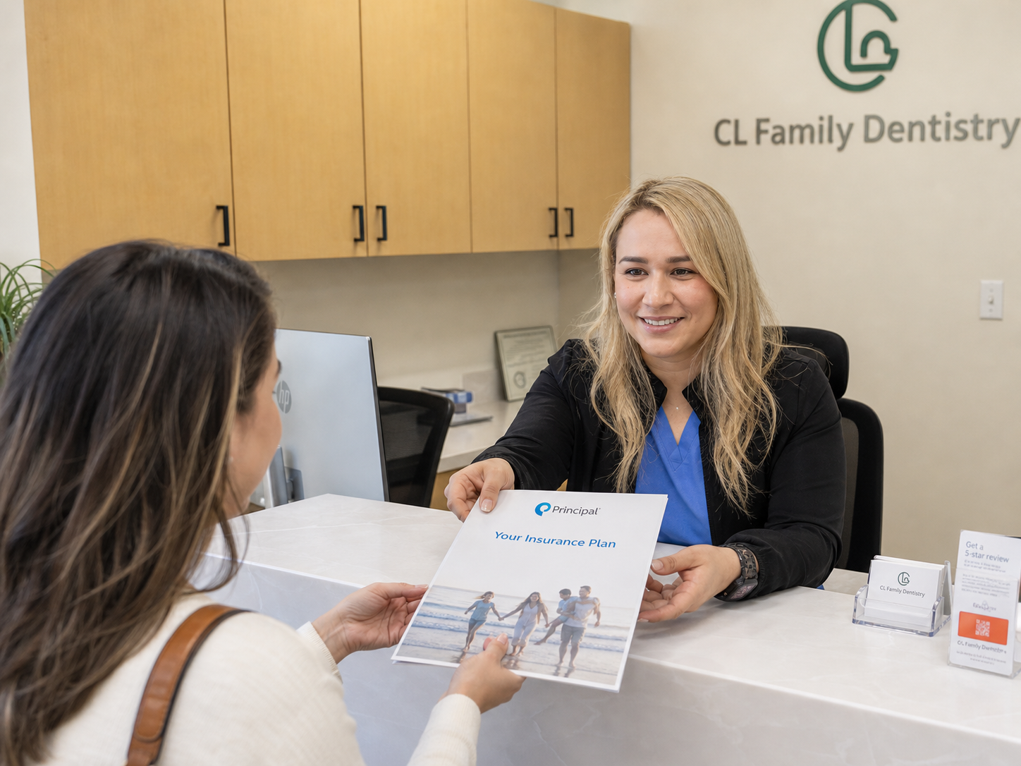 Office assistant at a modern dental reception desk warmly hands a Principal insurance plan brochure to a patient, with natural lighting, a clean workspace, and a welcoming atmosphere.