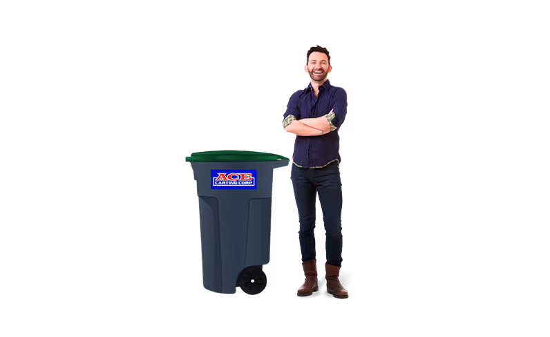 Man standing with arms crossed next to a large dark gray recycling cart with a green lid and blue ACE label.