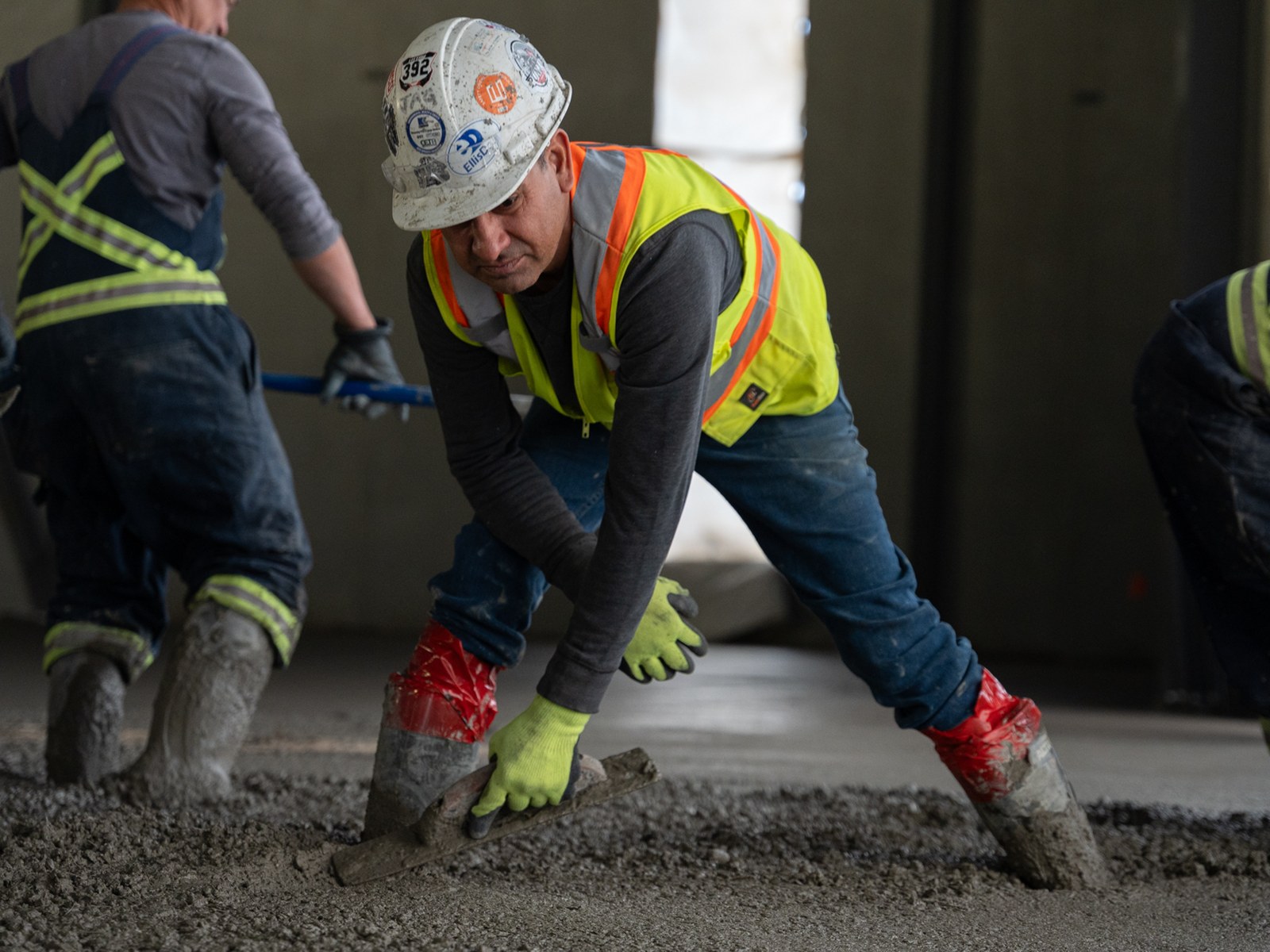 Finishers working wet concrete with hand trowels during the Starfield slab pour