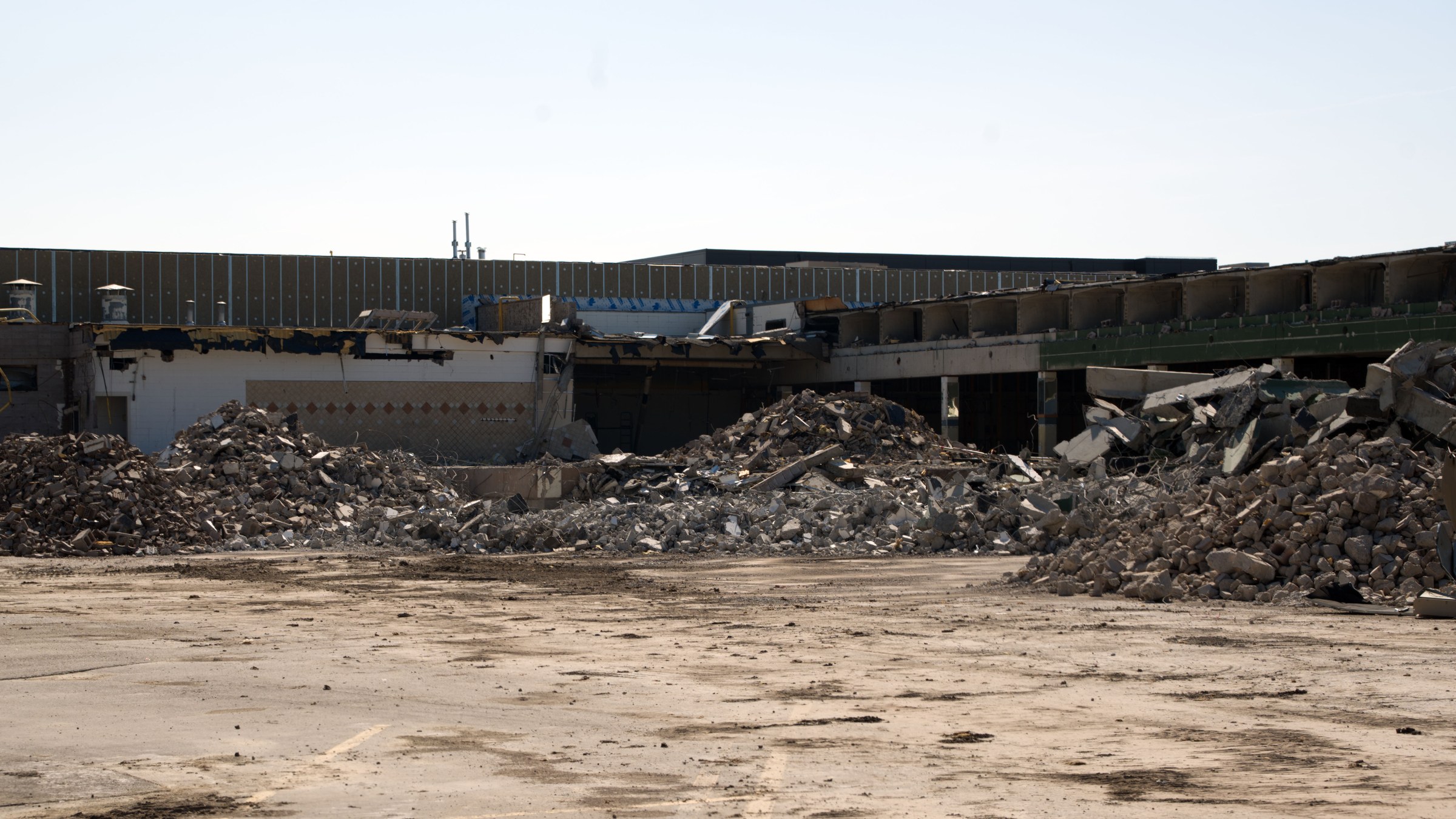 The stripped retail row and rubble piles at the Oakridge Co-op demolition, Calgary