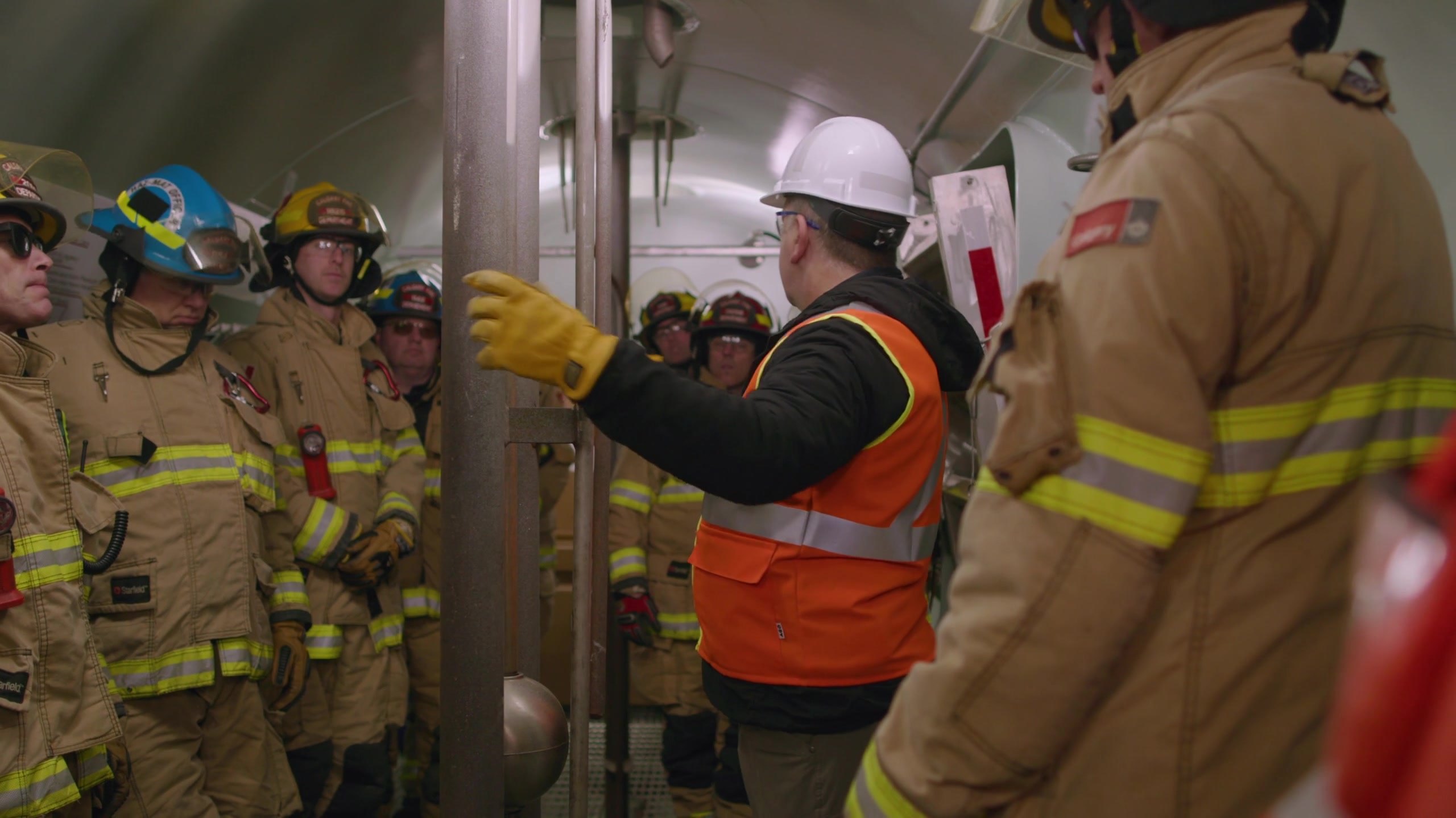 An instructor demonstrating a valve fitting to responders inside a CPKC transfer trailer at HazMat Days