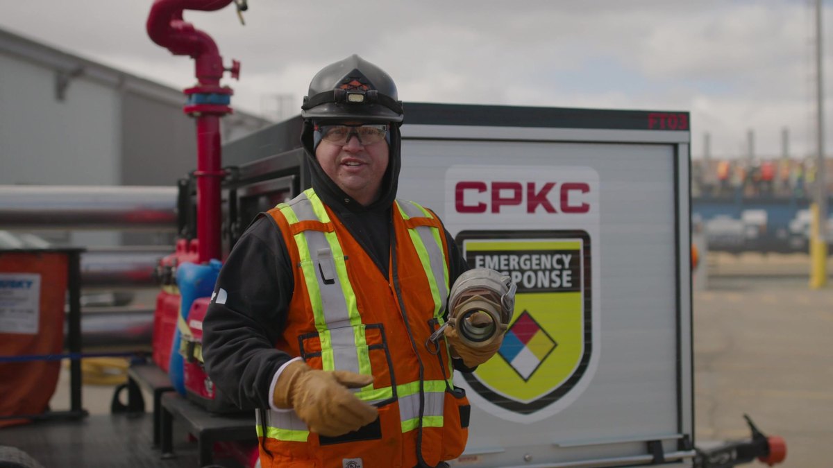 A CPKC emergency response officer beside a branded response trailer and manifold