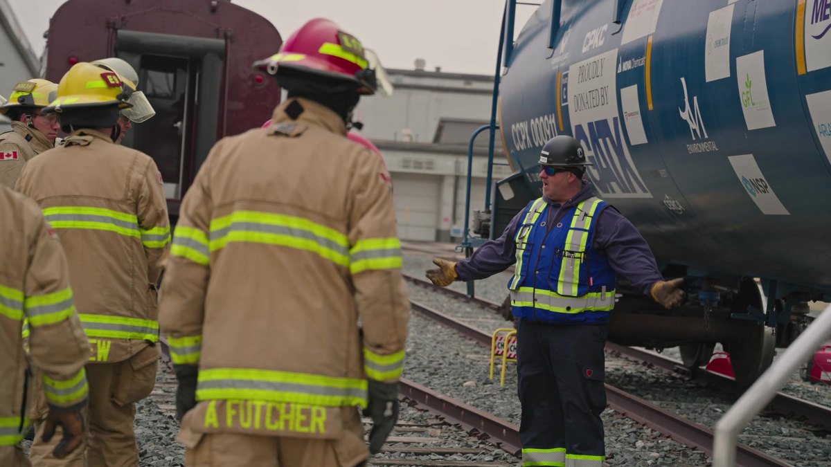 Crews in bunker gear at the CCPX 911 training tank car with an instructor trackside