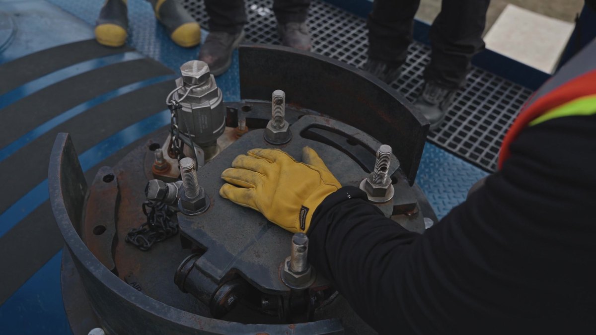 A gloved hand working the fittings on top of the CCPX 911 tank car dome