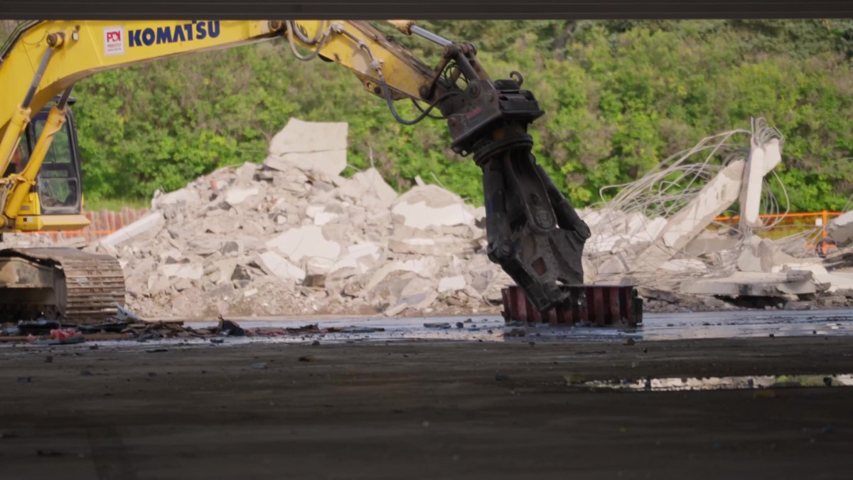 A Komatsu shear crushing a concrete column at the Oakridge Co-op demolition