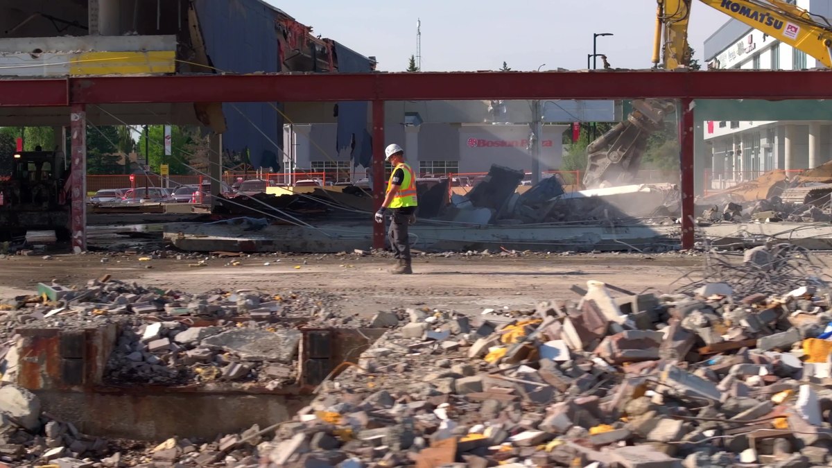 A worker in hi-vis inside the stripped steel frame of the Oakridge retail row