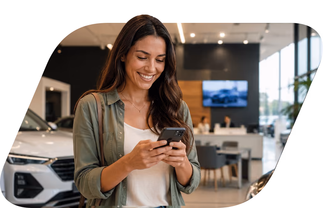 Mulher sorrindo enquanto usa o celular em frente a um carro branco em uma concessionária