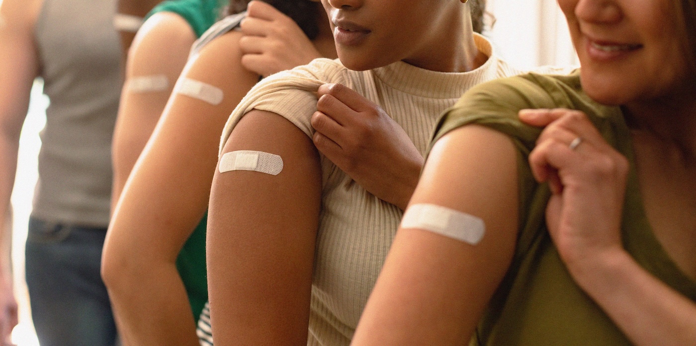 Participants showing bandages on their upper arms after vaccination for clinical or health research.