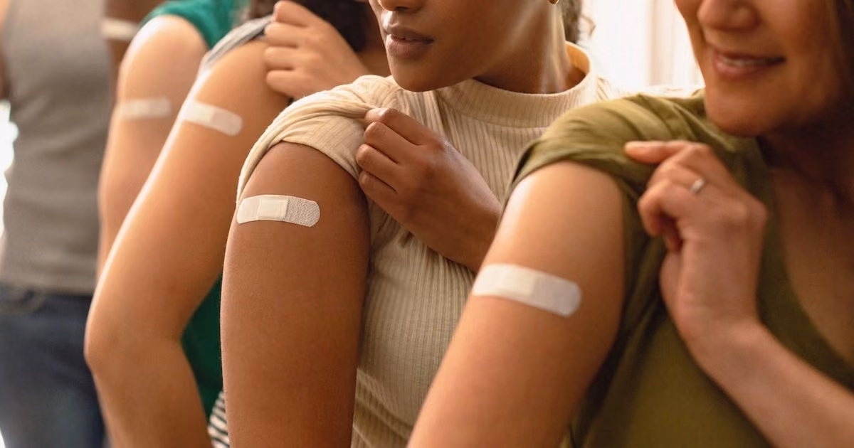 Participants showing bandages on their upper arms after vaccination for clinical or health research.