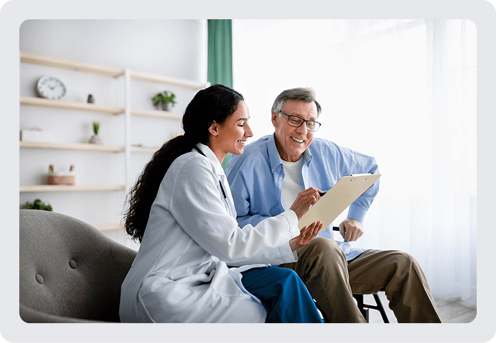 a doctor with an older male patient review results on a clipboard