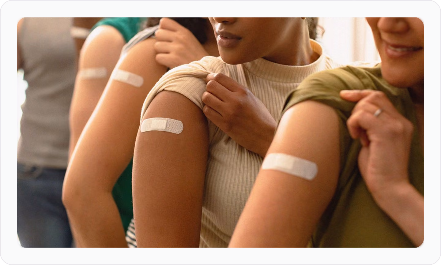 People displaying adhesive bandages after receiving vaccinations.