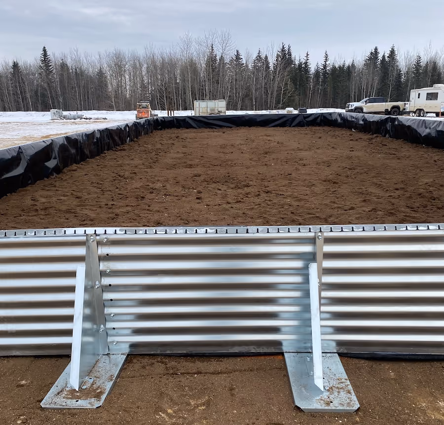 Large rectangular containment with soil inside, surrounded by metal panels and black liner outdoors.