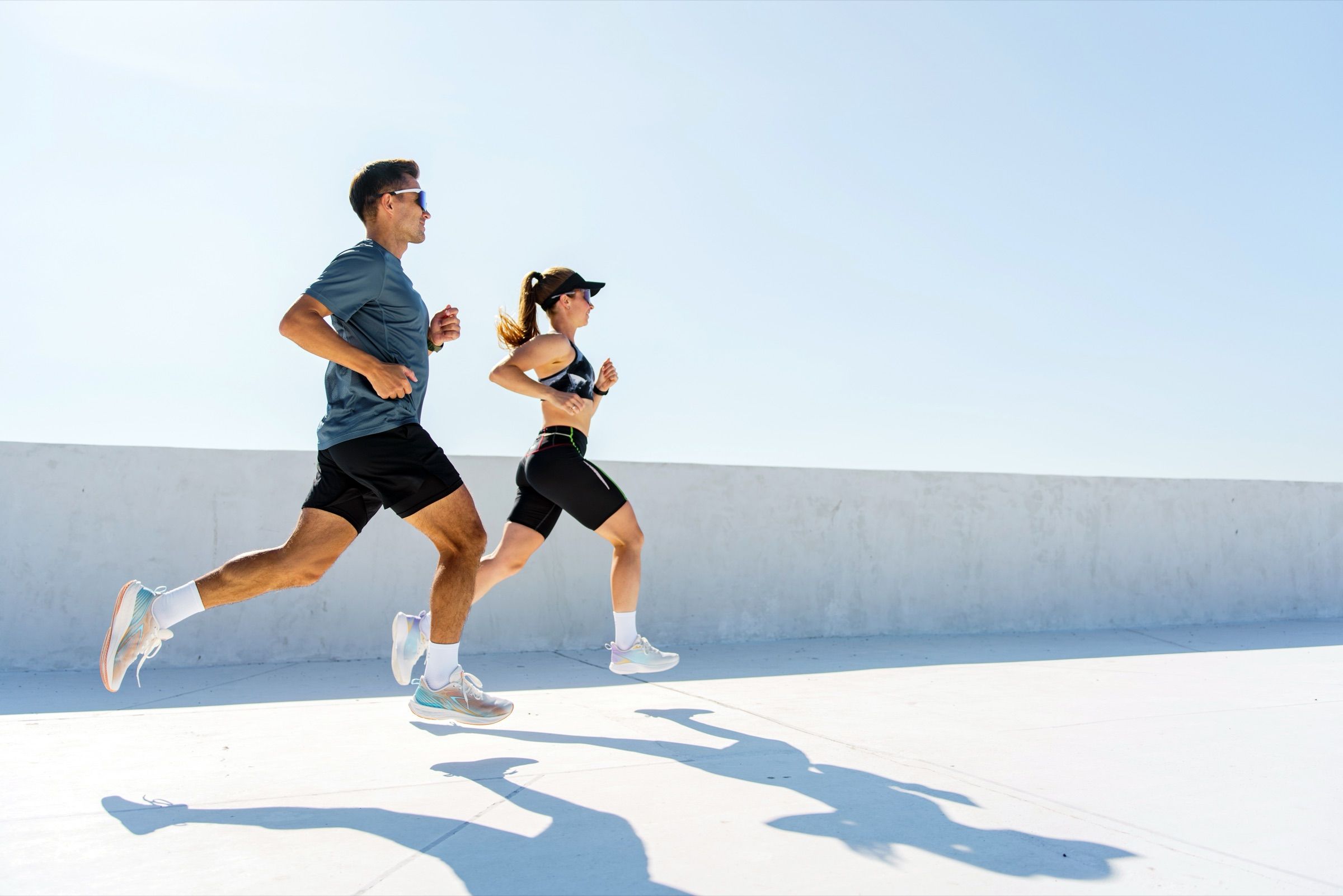 Couple running together outdoors on a sunny day