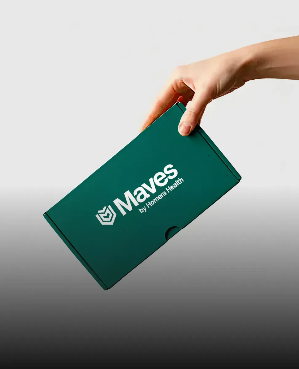 Hand holding a green box labeled Maves by Homera Health on a gray background.