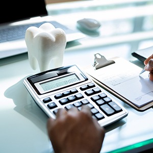 Person calculating cost of dental implants