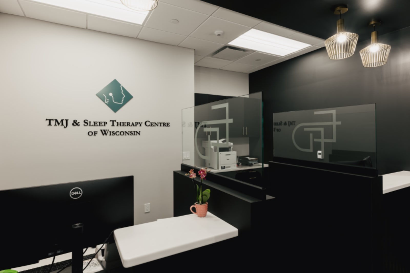 Modern dental treatment room at Elmbrook Family Dental with black cabinetry and white countertops.