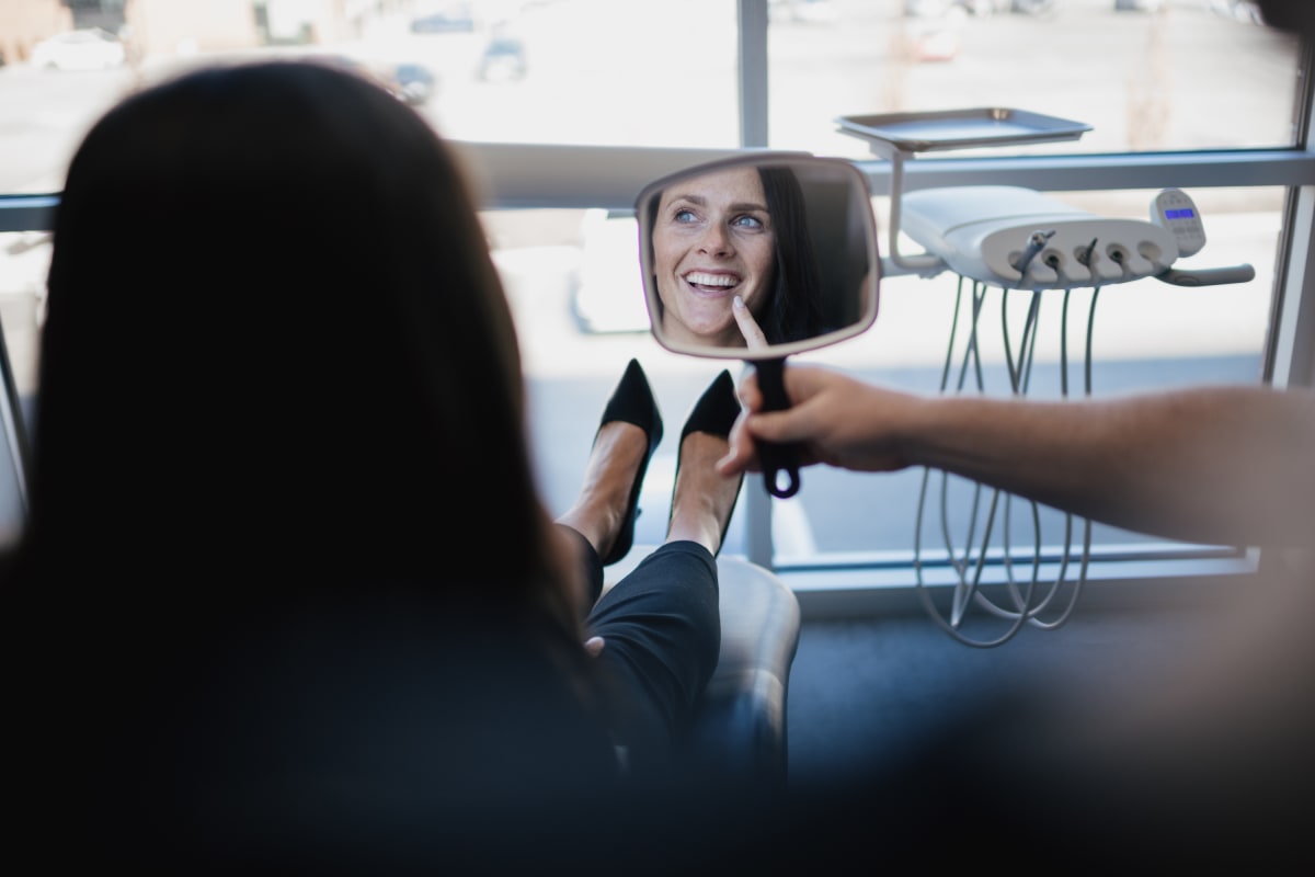 Dentist discussing treatment options with patient in dental office consultation room.