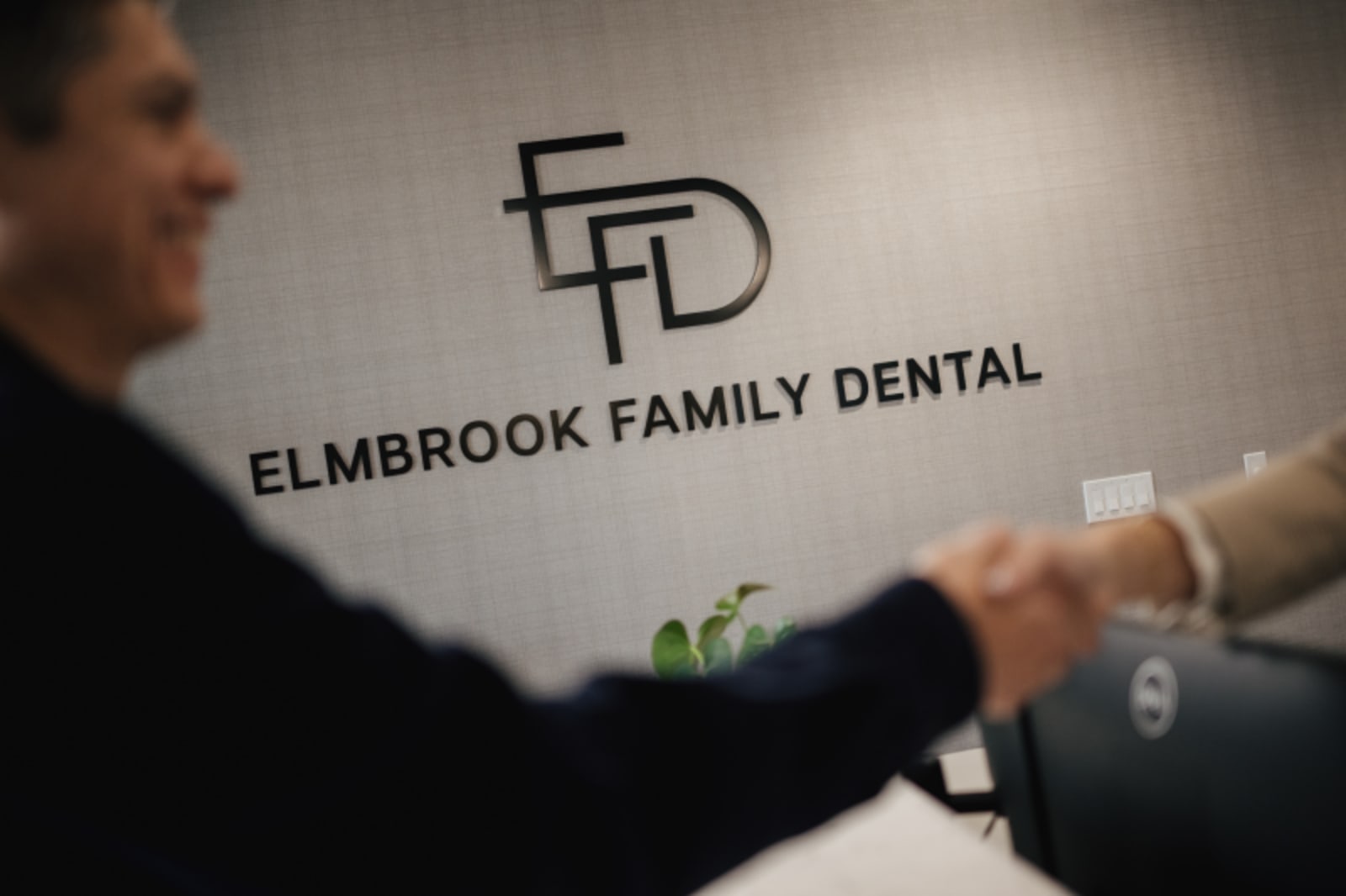 Dentist showing Invisalign aligners to a patient during a consultation at Elmbrook Family Dental.