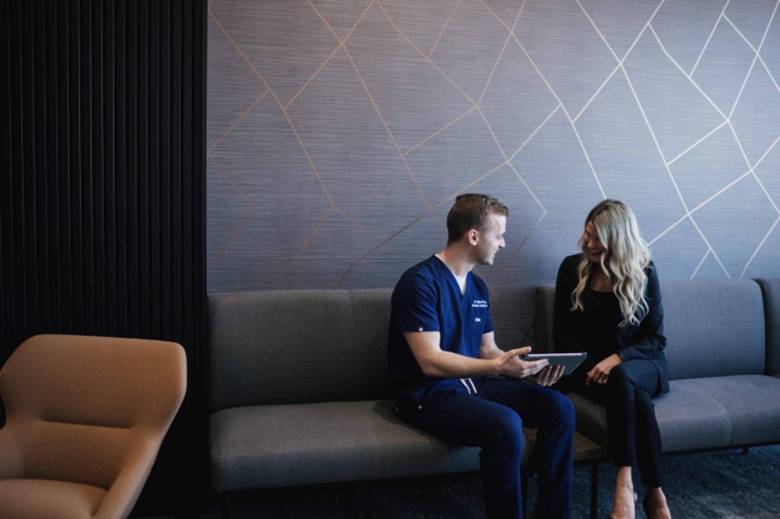Male and female dental professionals discussing patient care in a modern dental office consultation area.