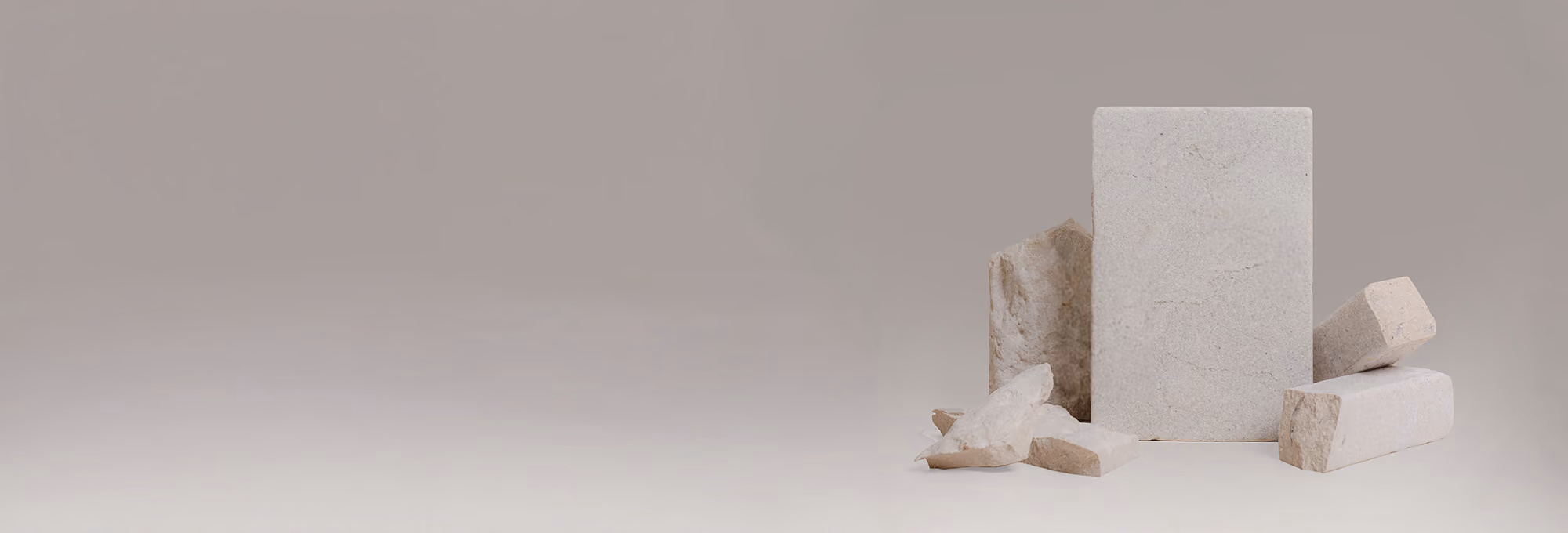 Various beige stone blocks and fragments arranged on a plain surface with a neutral background.