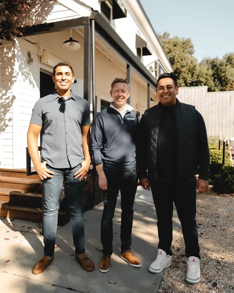 Three Connector JPA team members stand together outside a white building at a corridor tour stop