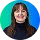 Young woman with brown hair and blue shirt smiling against a blue background.