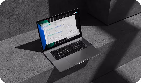Laptop on concrete steps displaying analytics dashboard with charts and graphs on screen.