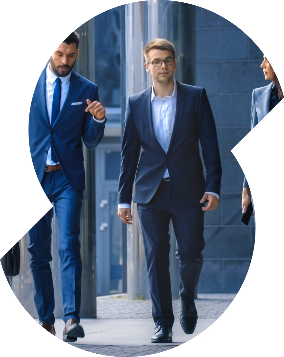 Drie zakelijke professionals lopen buiten, twee mannen in pakken en een vrouw met een smartphone.