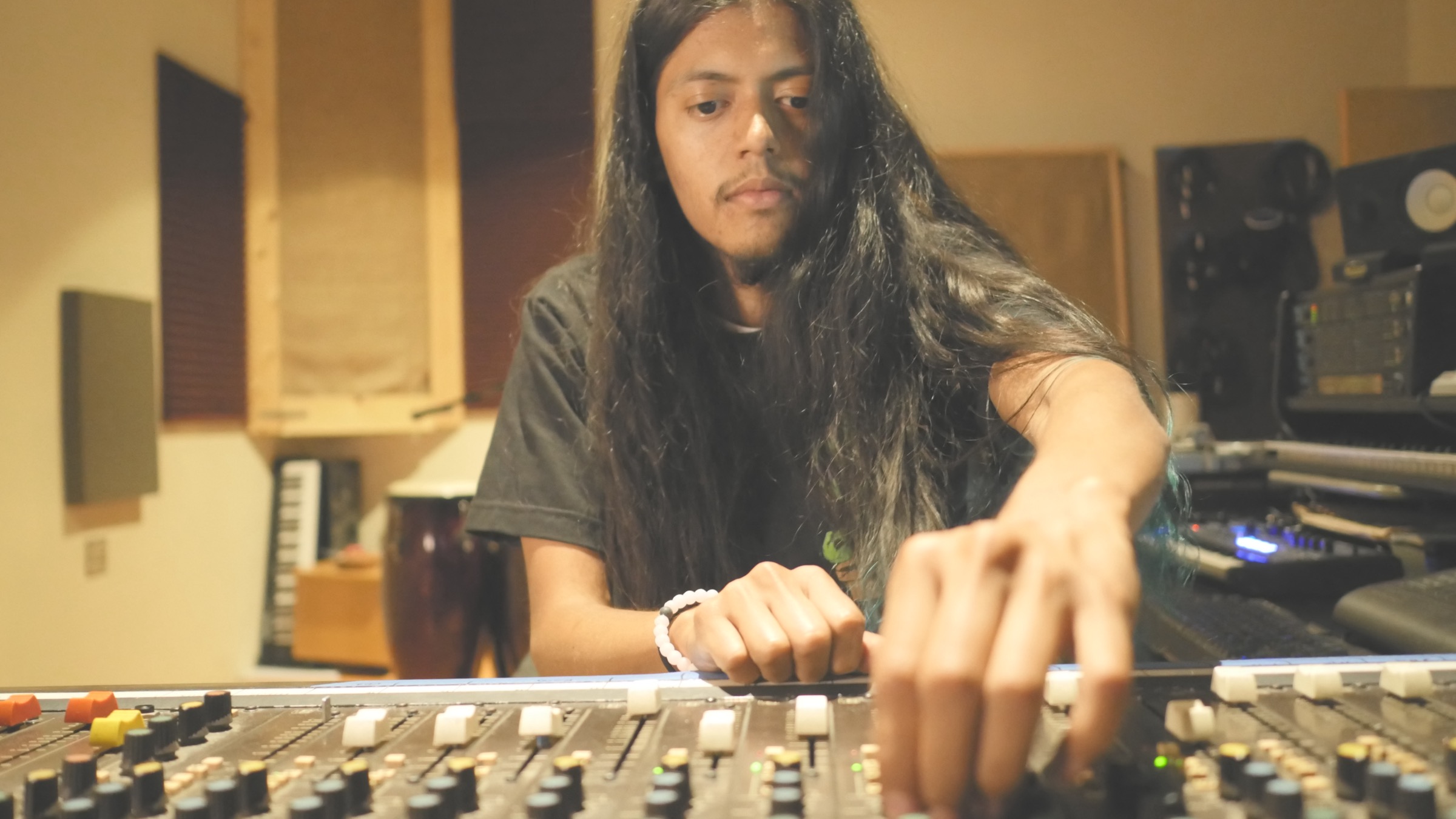 Musician working the mixing console during the Wholesounds studio session filmed by NEEBA Studios