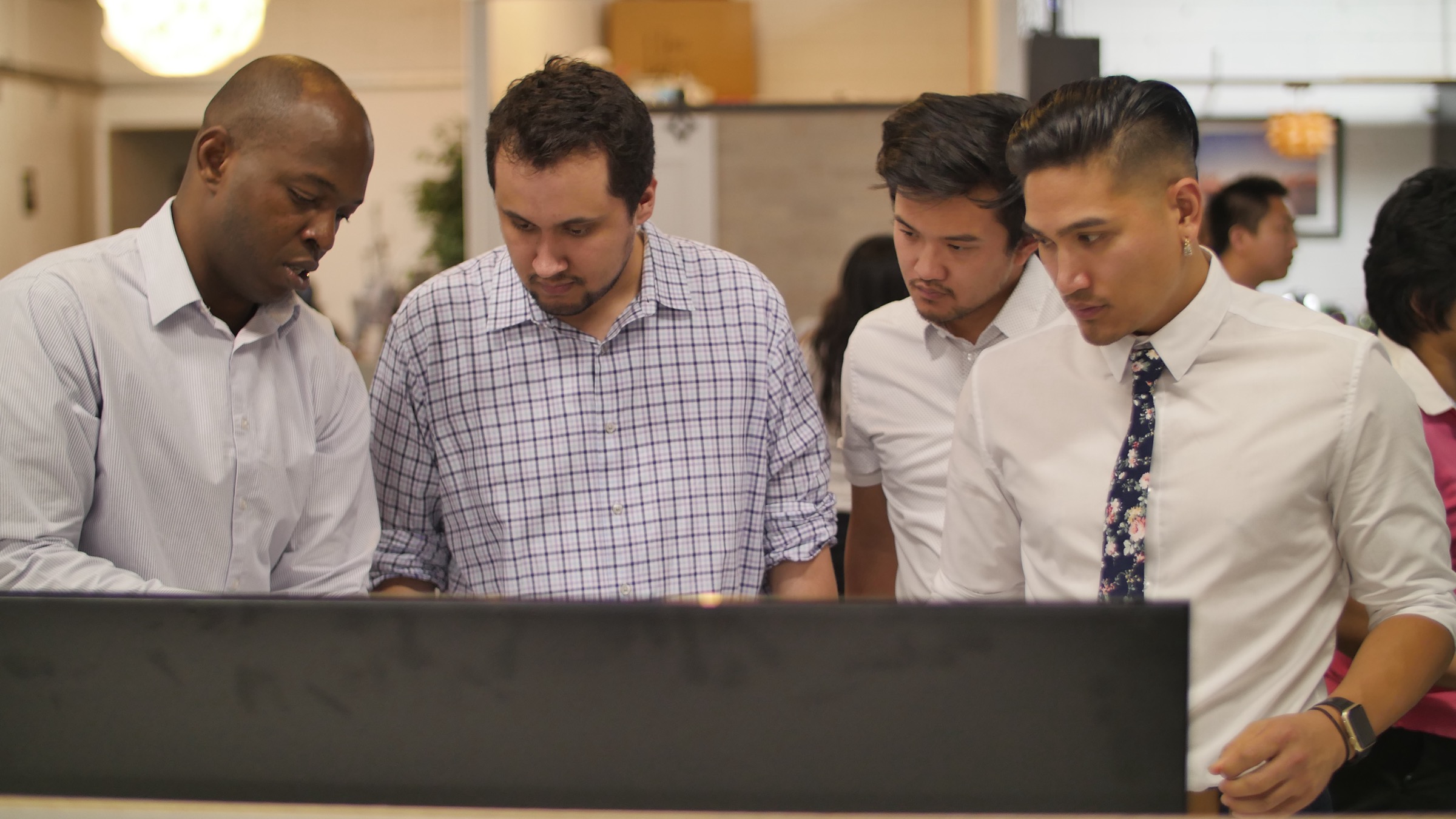 Marlo Custodio and the NEEBA crew reviewing a display with entrepreneurs at the ActionSpot incubator in San José