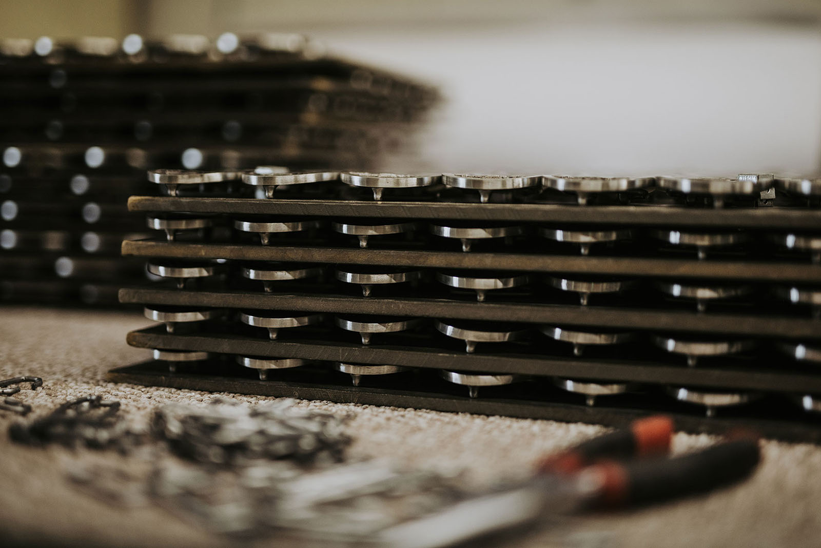 Custom pewter buckles stacked in trays during production
