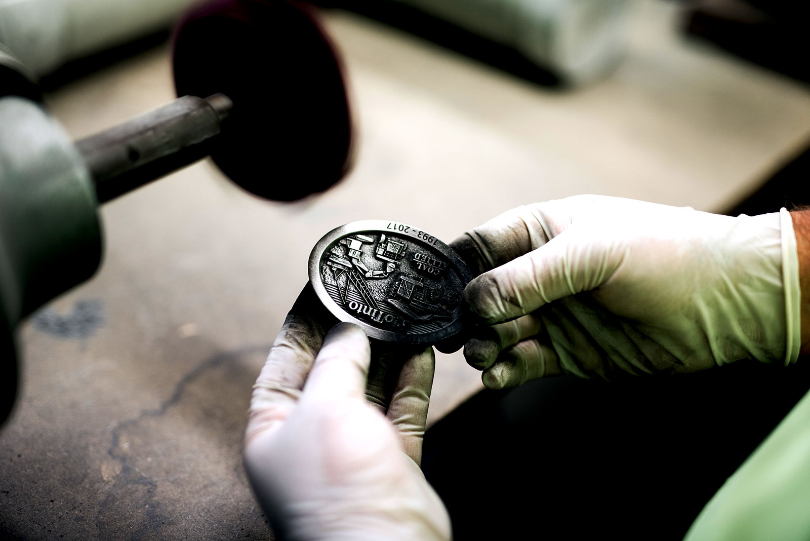Hand finishing and polishing a custom Rio Tinto commemorative buckle during production