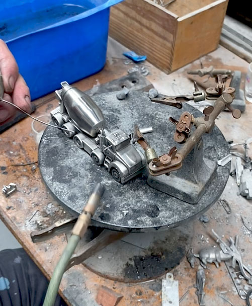 Craftsman assembling a pewter cement truck model during production in the Buckingham Pewter workshop.