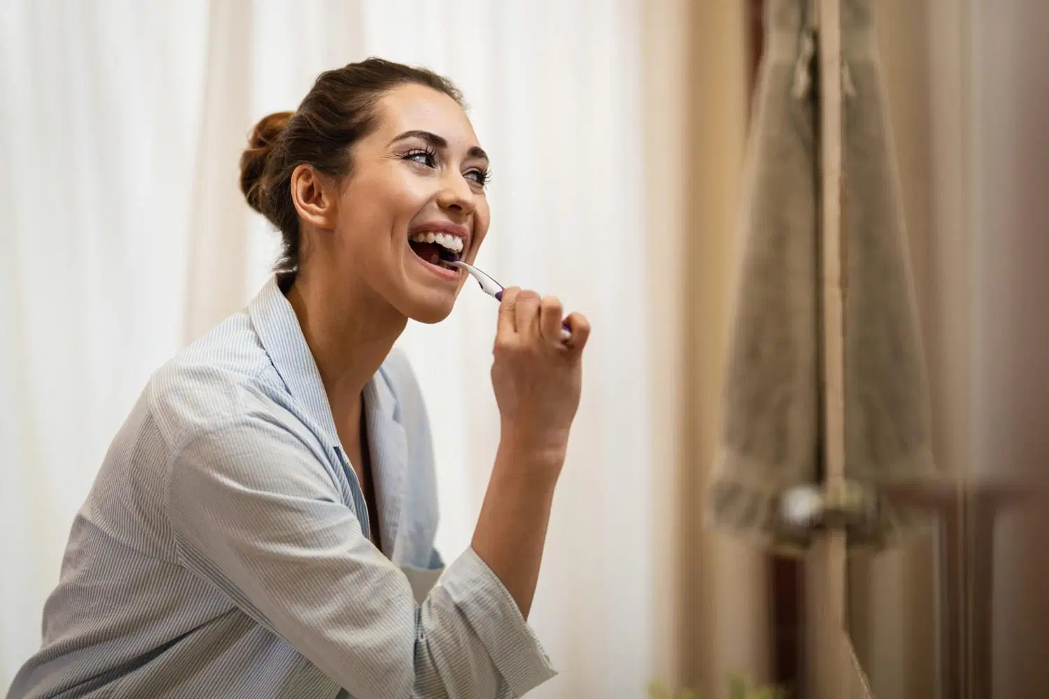 Patient brushing teeth gently with a soft-bristled toothbrush