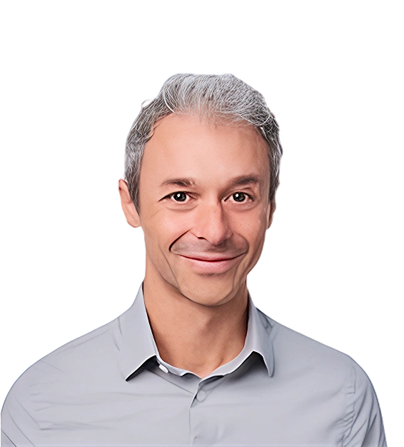 Smiling middle-aged man with short gray hair wearing a light gray button-up shirt.