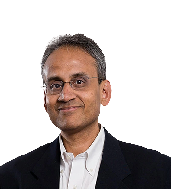 Man with short gray hair and glasses wearing a white shirt and black blazer smiling slightly.