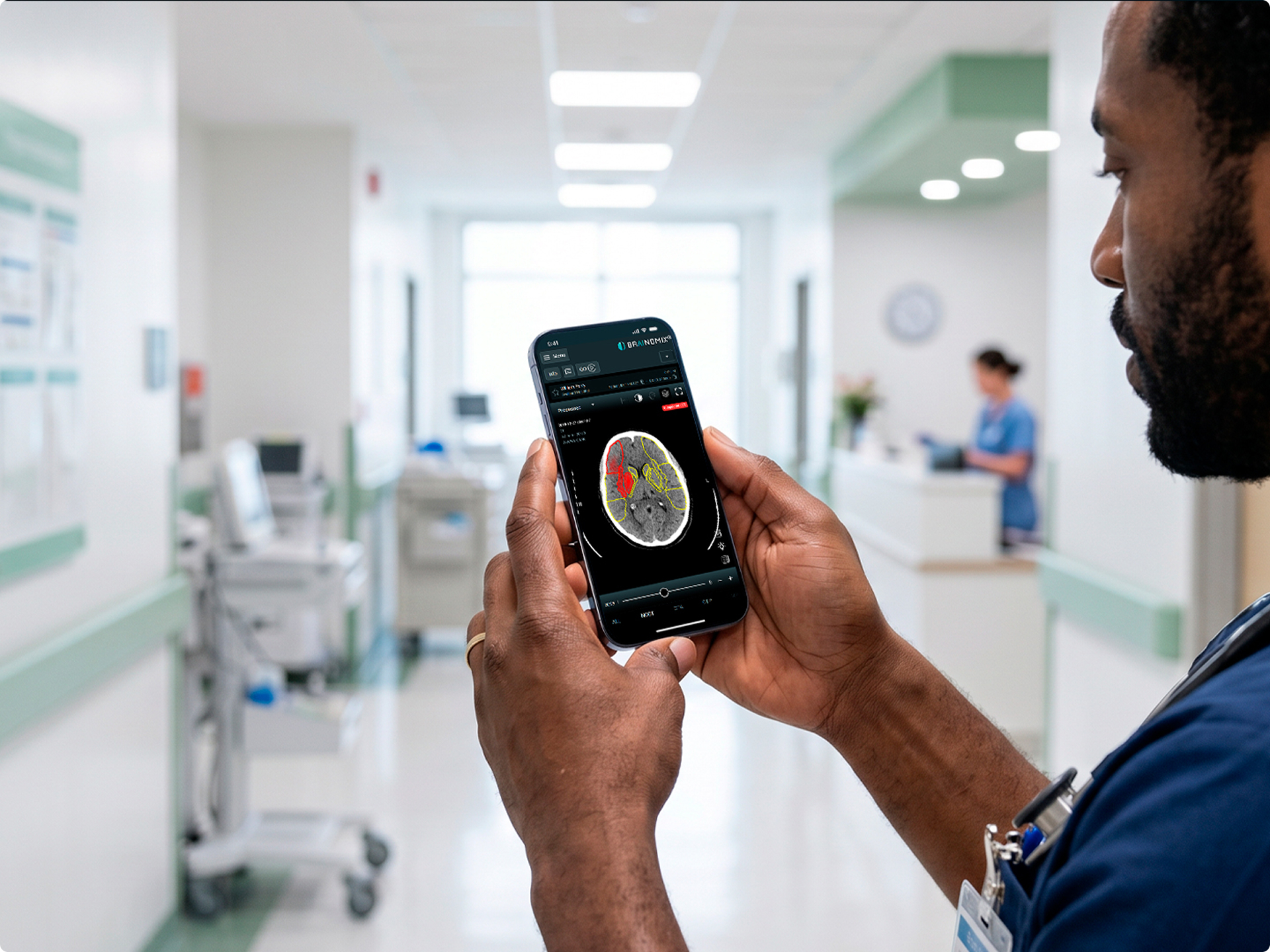 Medical professional holding phone displaying brain scan with highlighted areas in a hospital hallway.