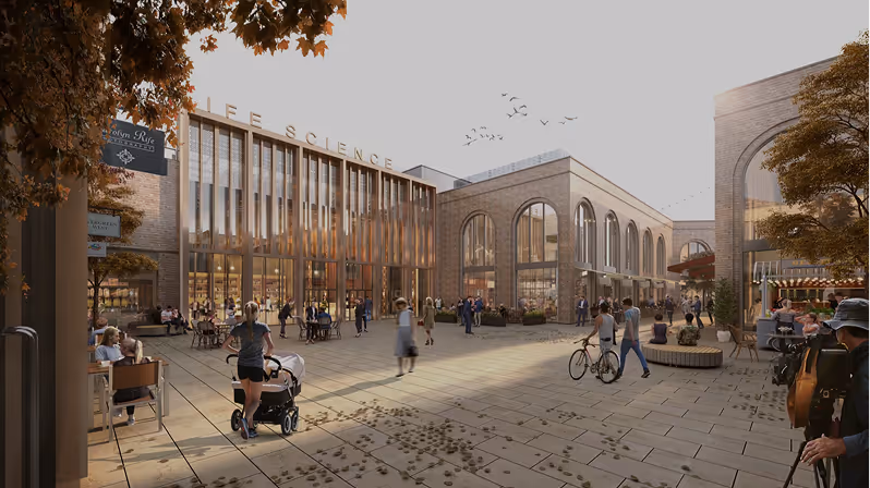 Outdoor plaza with people walking, biking, and sitting near a modern Life Science building in autumn.